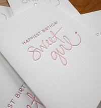 Handmade white folding birthday card with letterpress quality saying Happy Birthday Sweet Girl. 