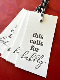 Cotton letterpress champagne gift tags saying, "This Calls for Bubbly"