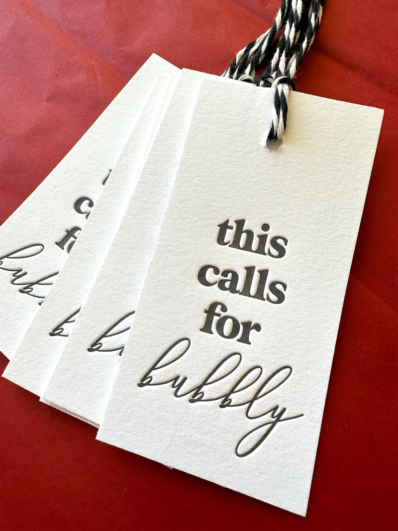 Cotton letterpress champagne gift tags saying, "This Calls for Bubbly"