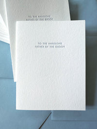 White card with text 'To the handsome father of the groom' on a blue envelope.