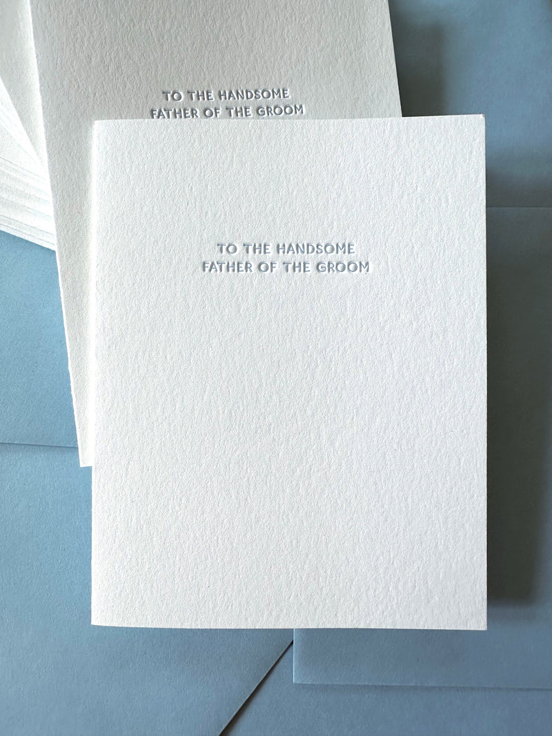 White card with text 'To the handsome father of the groom' on a blue envelope.