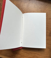 Open Thanksgiving journal displaying smooth, blank, unlined pages inside handmade persimmon cover