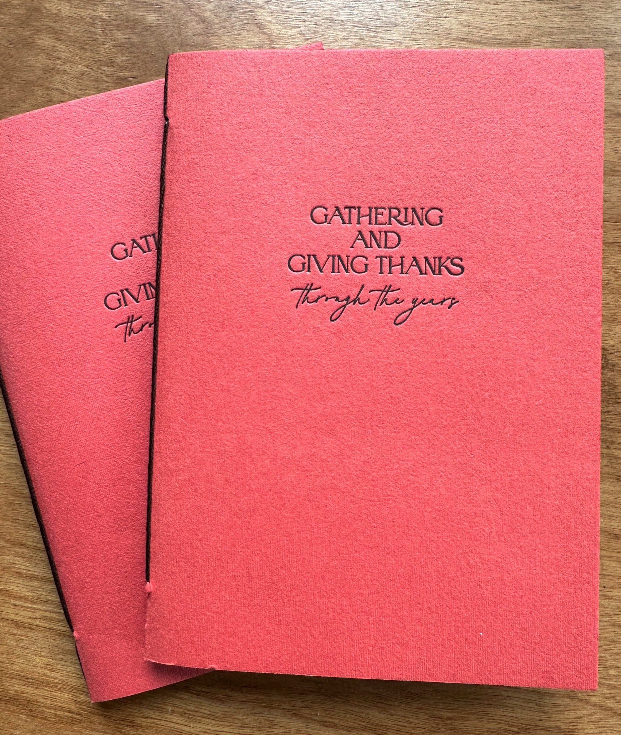 Thanksgiving memory journal shown at an angle, featuring coppery-persimmon handmade paper cover and letterpress chocolate ink lettering