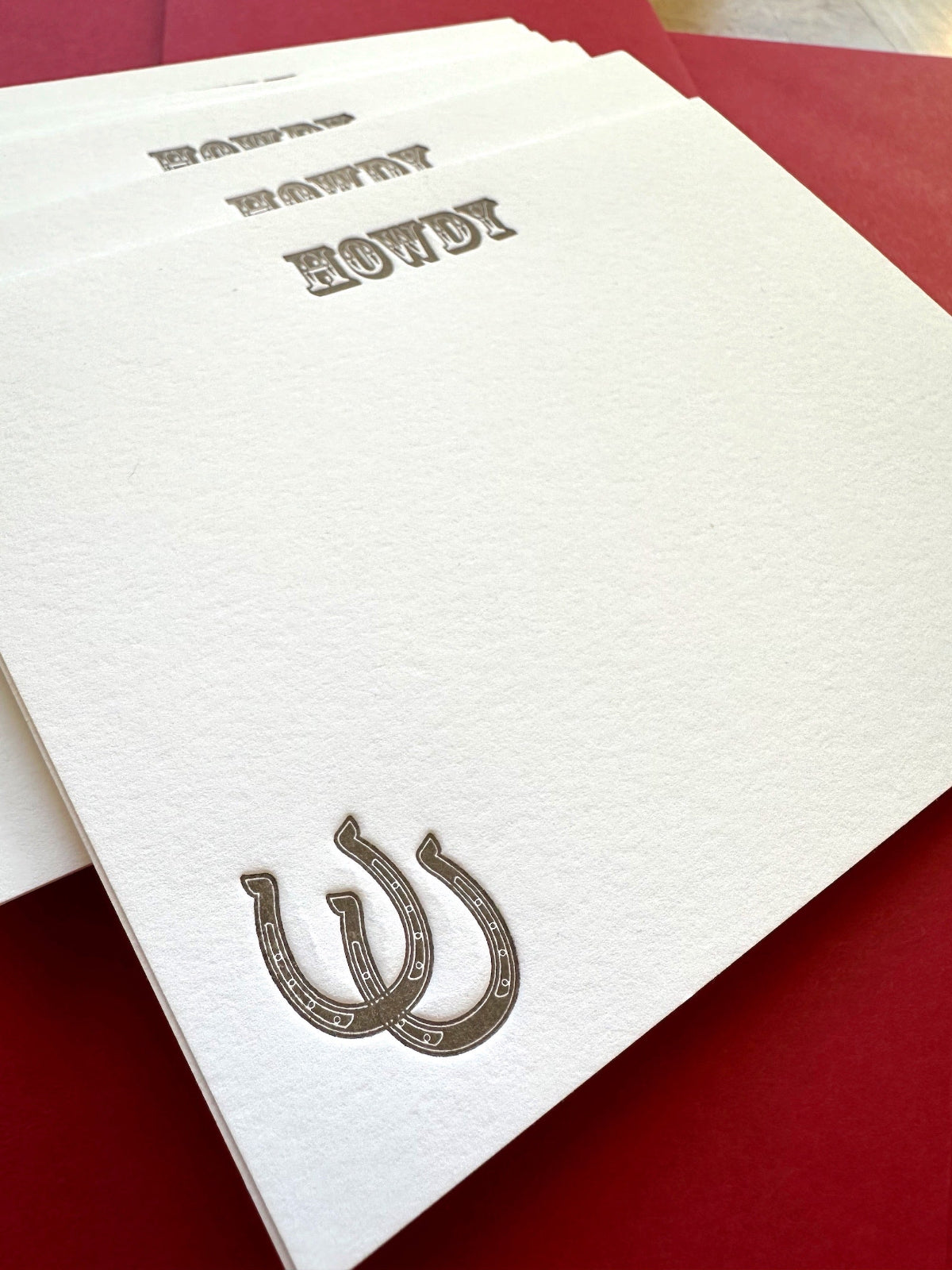 Western-style letterpress card featuring horseshoe and Howdy message in brown ink