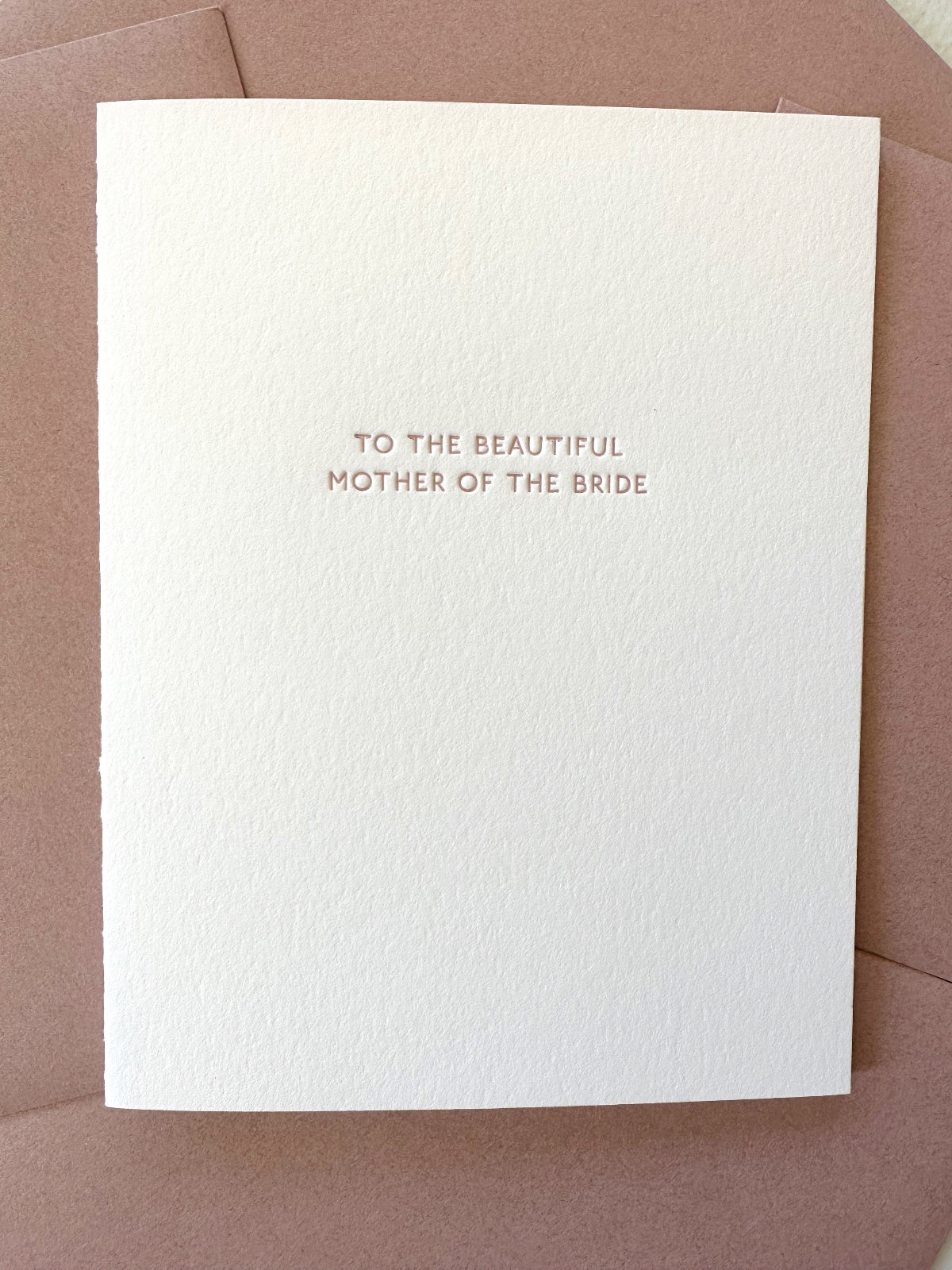 White card with 'To the beautiful mother of the bride' text on a rose envelope