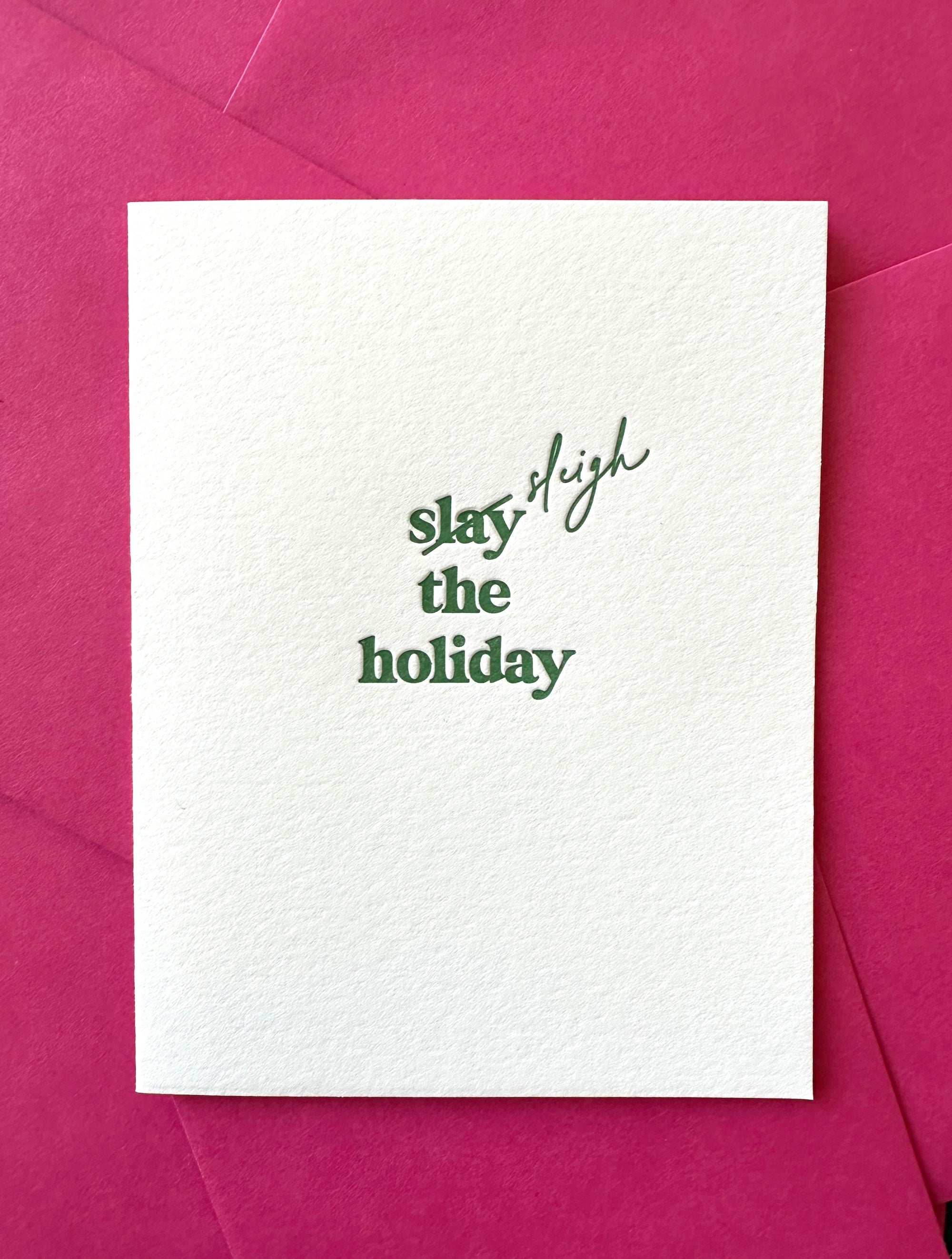 Letterpress holiday card with green “Slay (Sleigh) the Holiday!” text, paired with a pink envelope – modern and festive Christmas card