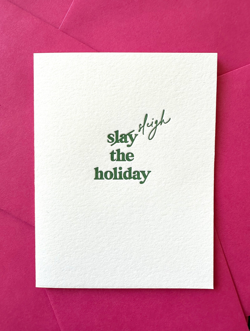 Letterpress holiday card with green “Slay (Sleigh) the Holiday!” text, paired with a pink envelope – modern and festive Christmas card